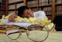 śpiący prawnik na kodeksach i notatkach